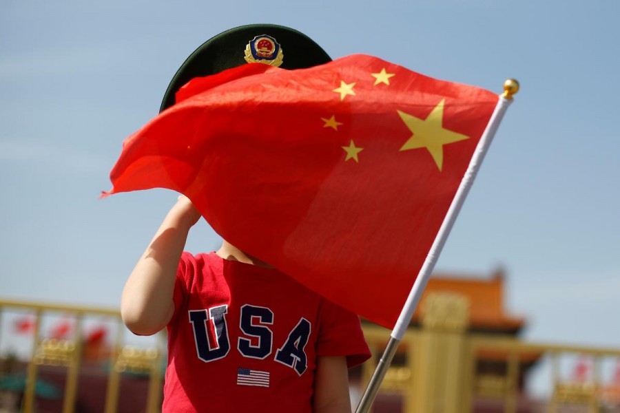 A boy wearing an US t-shirt waves a Chinese national flag in Tiananmen Square in Beijing, China, May 7, 2019. Reuters/File Photo