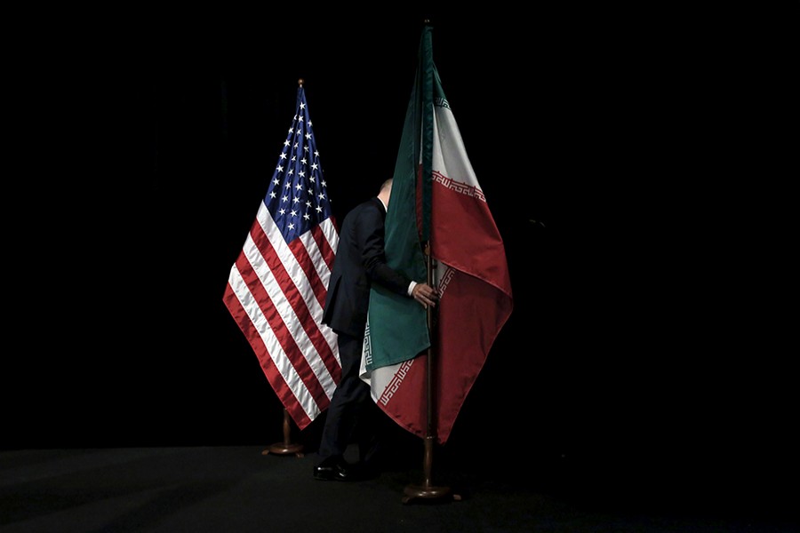 A staff member removes the Iranian flag from the during Iran nuclear talks at the Vienna International Center in Vienna, Austria on July 14, 2015 — Reuters/Files