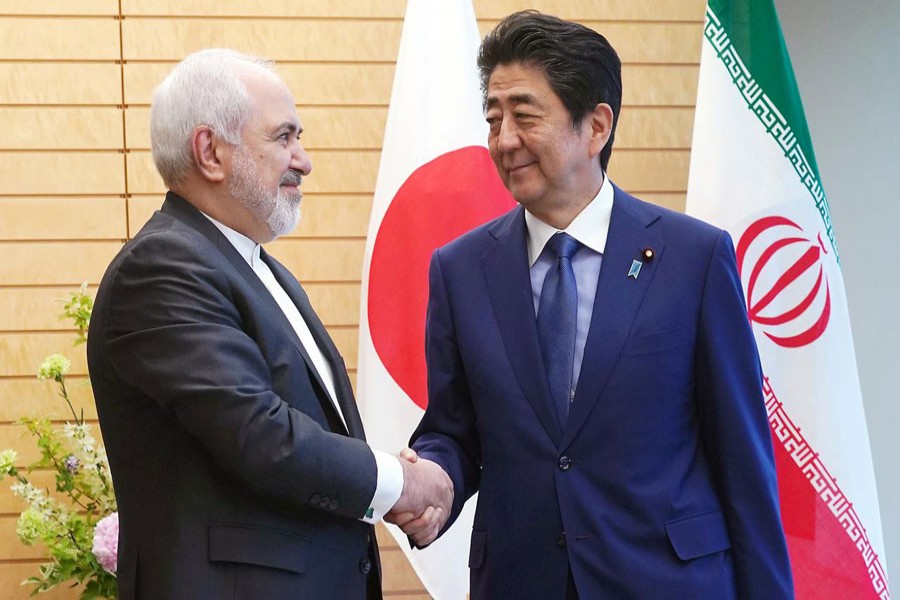 Iranian Foreign Minister Mohammad Javad Zarif, left, and Japanese Prime Minister Shinzo Abe, right, shake hands at Abe's official residence in Tokyo Thursday, May 16, 2019. Eugene Hoshiko/Pool via Reuters