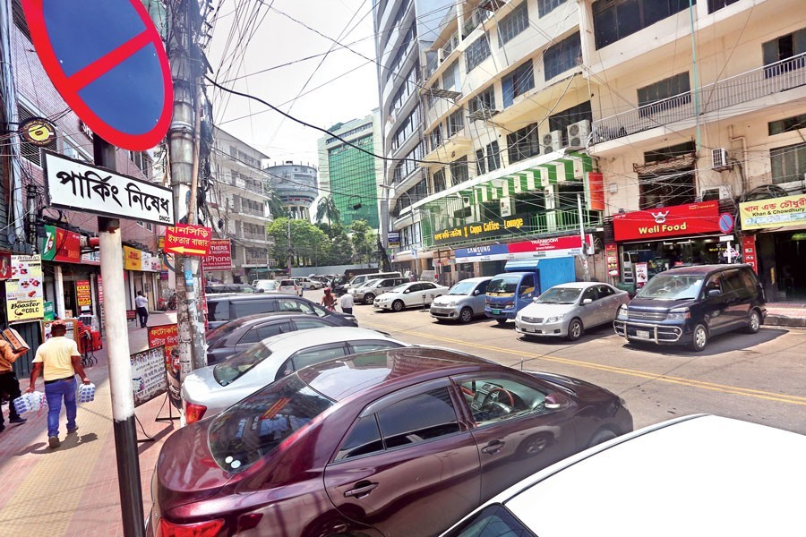 Many cars are parked illegally on a key road at Gulshan 2 in the city on Tuesday despite the no-parking sign being displayed prominently — FE photo