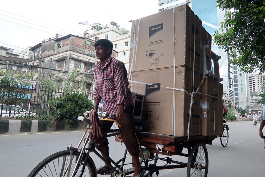 A rickshaw-van puller carrying freezers on his three-wheeler crossing the Paltan area in the city — FE Photo