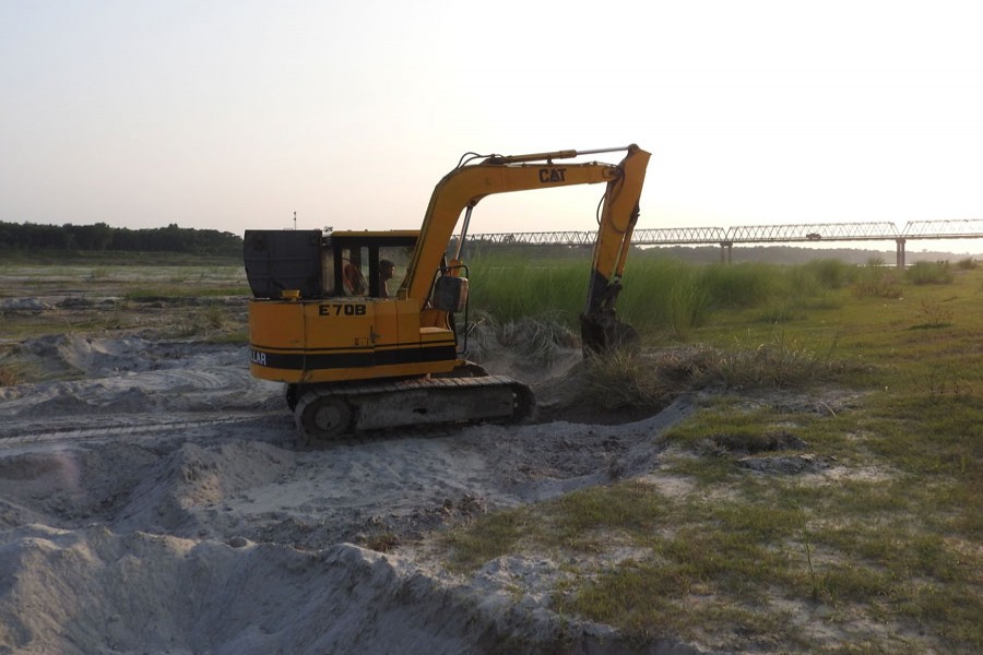 Sand lifting is going on by an excavator near the Gorai Bridge in Magura. The photograph was taken on Thursday   	— FE Photo