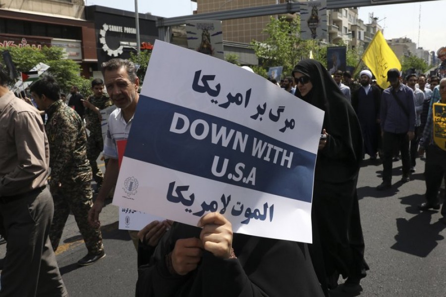 FILE - In this May 31, 2019 file photo, a demonstrator holds an anti-US placard during the annual Quds, or Jerusalem Day rally in Tehran, Iran. The top line on the placard in Farsi translates to, Death to America, and the bottom line on the placard in Arabic translates to, Death to America - AP Photo/Vahid Salemi