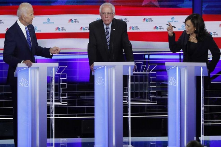 Former Vice President Joe Biden defends his record on racial issues with Senator Kamala Harris as Senator Bernie Sanders listens during the second night of the first US Democratic presidential candidates 2020 election debate in Miami, Florida, US, June 27, 2019. Reuters