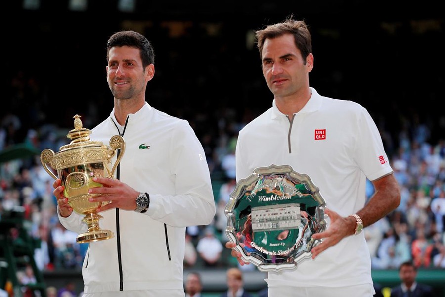 Serbia's Novak Djokovic celebrates winning the final as he and Switzerland's Federer pose with their trophies — Reuters photo