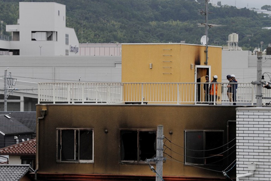 Firefighters are seen checking an entrance at the rooftop of the torched Kyoto Animation building in Kyoto