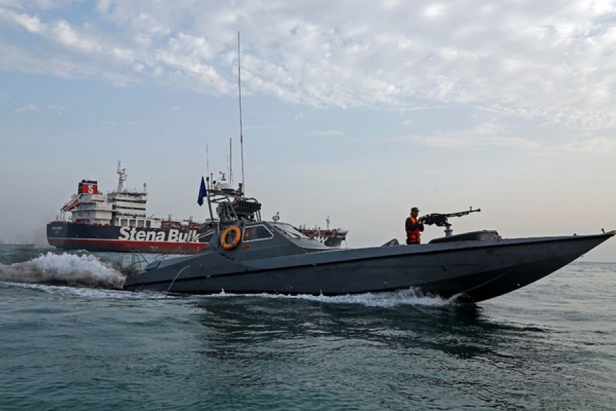 A boat of the Iranian Revolutionary Guard sails next to Stena Impero, a British-flagged vessel owned by Stena Bulk, at Bandar Abbas port, July 21, 2019. Iran, Mizan News Agency/WANA Handout via Reuters