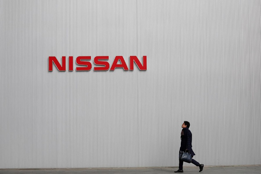 A man walks under the logo of Nissan Motor Co at the company's showroom in Yokohama, south of Tokyo on February 8, 2013 — Reuters/Files