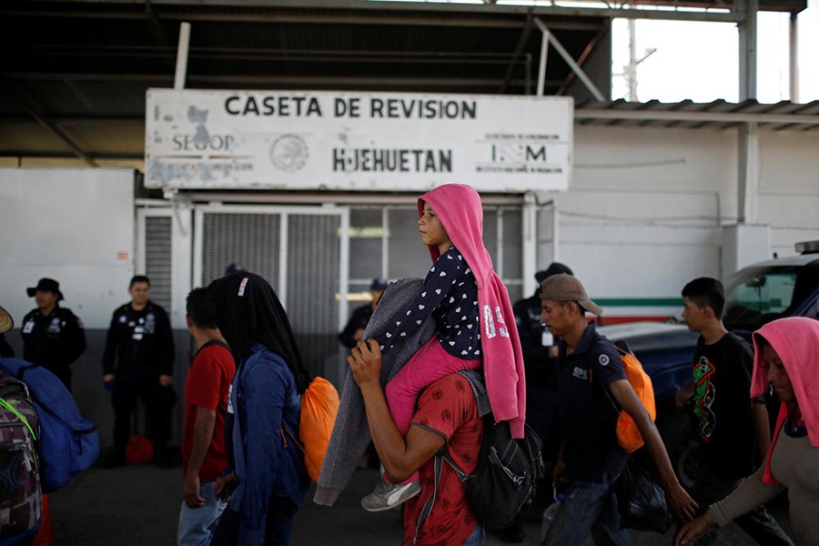 People belonging to a caravan of migrants from Honduras en route to the United States walk by an immigration checkpoint in Huehuetan, Mexico on April 15, 2019 — Reuters/Files