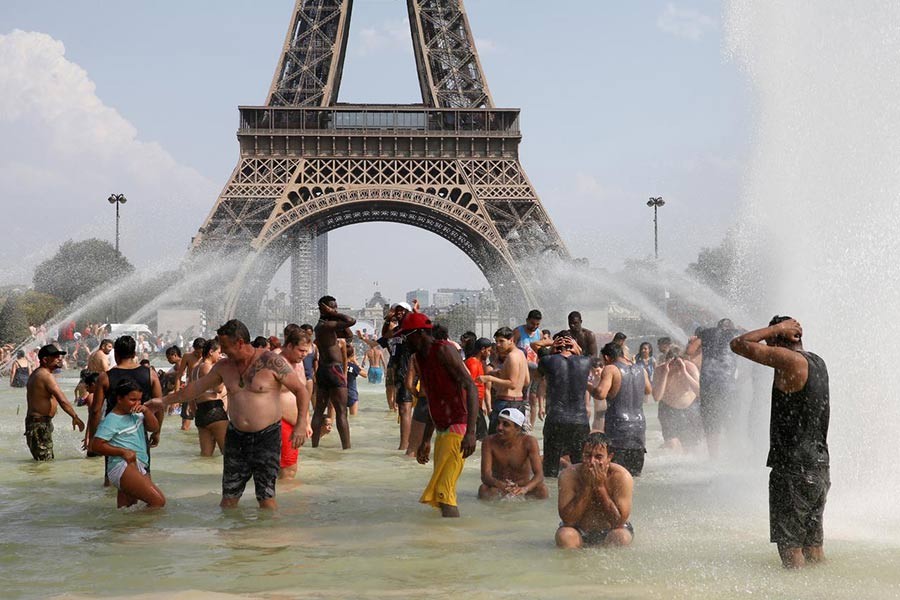 People cooling off in the Trocadero fountains across from the Eiffel Tower in Paris as a new heatwave broke temperature records in France. The photo was taken on July 25, 2019. -Reuters file photo
