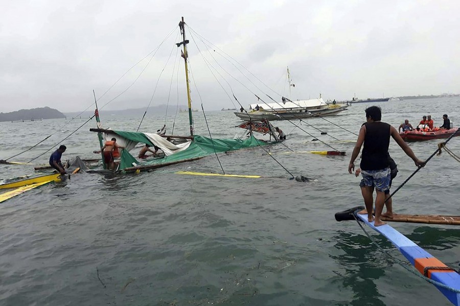 In this photo provided by the Philippine Red Cross, rescuers checks the remains of a ferry boat after it capsized due to bad weather in the waters between Guimaras and Iloilo provinces, central Philippines on Saturday August 3, 2019 — Philippine Red Cross via AP