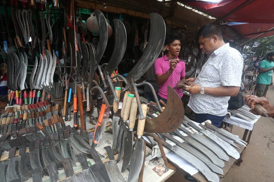 A customer is making a choice of slaughtering tools at a shop in the city's Karwan Bazar on Wednesday as the trader displayed a good collection of the equipment ahead of the Eid-ul-Azha — FE Photo