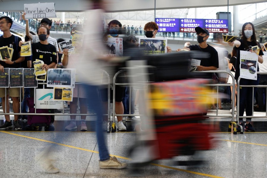 Anti-extradition bill protesters hold up placards for arriving travellers during a protest at the arrival hall of Hong Kong International Airport in Hong Kong, China August 9, 2019. REUTERS/Thomas Peter