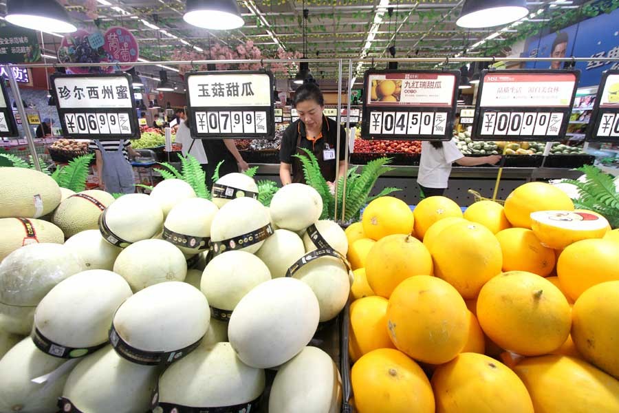 A saleswoman arranges fruit at a supermarket in Handan, north China's Hebei Province, June 12, 2019. - Xinhua