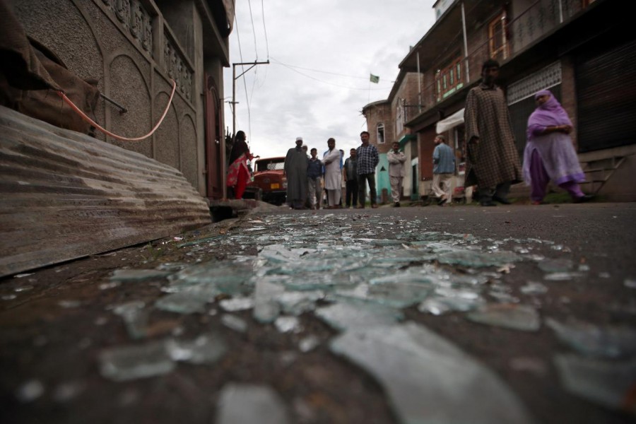 Kashmiris walk past broken window glass after clashes between protesters and the security forces on Friday evening, during restrictions following the scrapping of the special constitutional status for Kashmir by the Indian government, in Srinagar August 17, 2019 - REUTERS/Danish Ismail