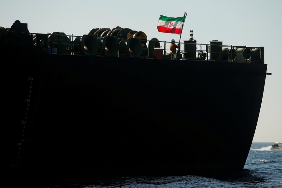 A crew member raises the Iranian flag on Iranian oil tanker Adrian Darya 1, previously named Grace 1, as it sits anchored after the Supreme Court of the British territory lifted its detention order, in the Strait of Gibraltar, Spain on August 18, 2019 — Reuters photo