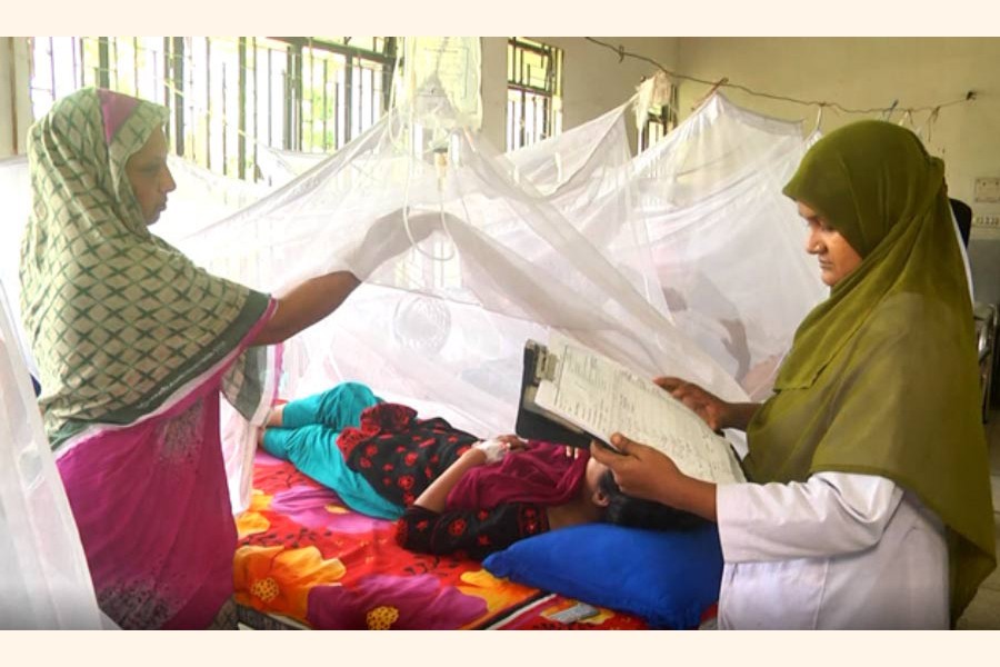 A doctor at Rajshahi Medical College and Hospital checking the reports of a dengue-affected patient on Sunday     	— FE Photo