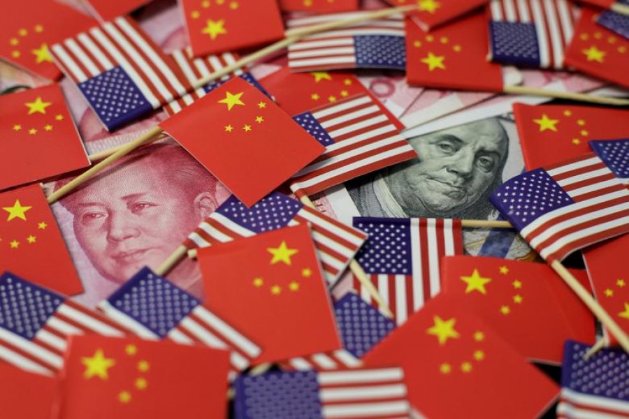 A US dollar banknote featuring American founding father Benjamin Franklin and a Chinese yuan banknote featuring late Chinese chairman Mao Zedong are seen among US and Chinese flags in this illustration picture taken May 20, 2019. Reuters/File Photo
