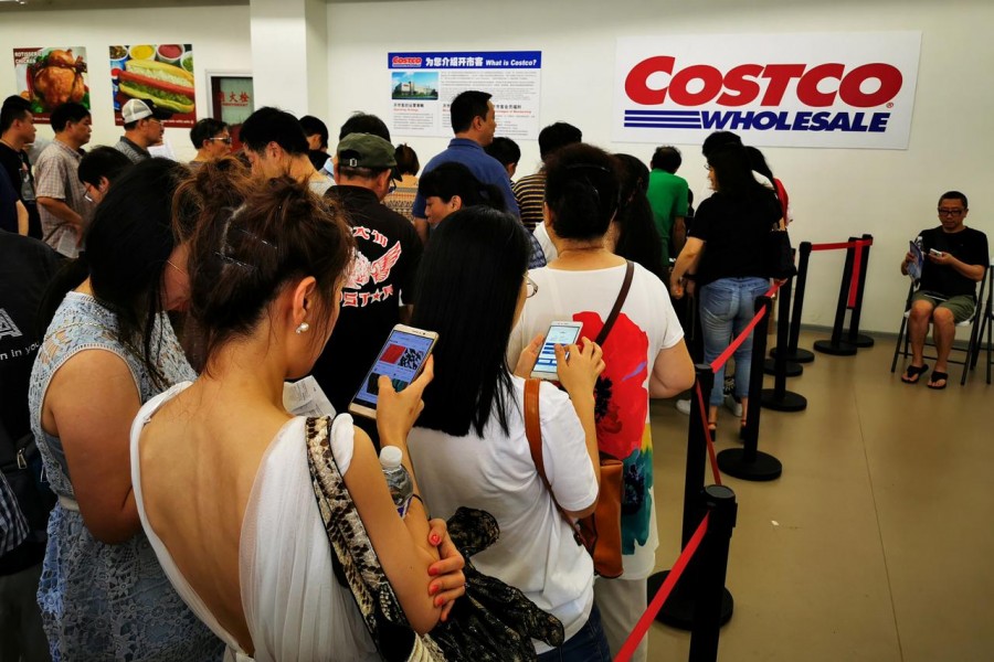 FILE PHOTO: People queue to sign up membership at a US hypermarket chain Costco Wholesale Corp store in Shanghai, China August 24, 2019. REUTERS/Stringer