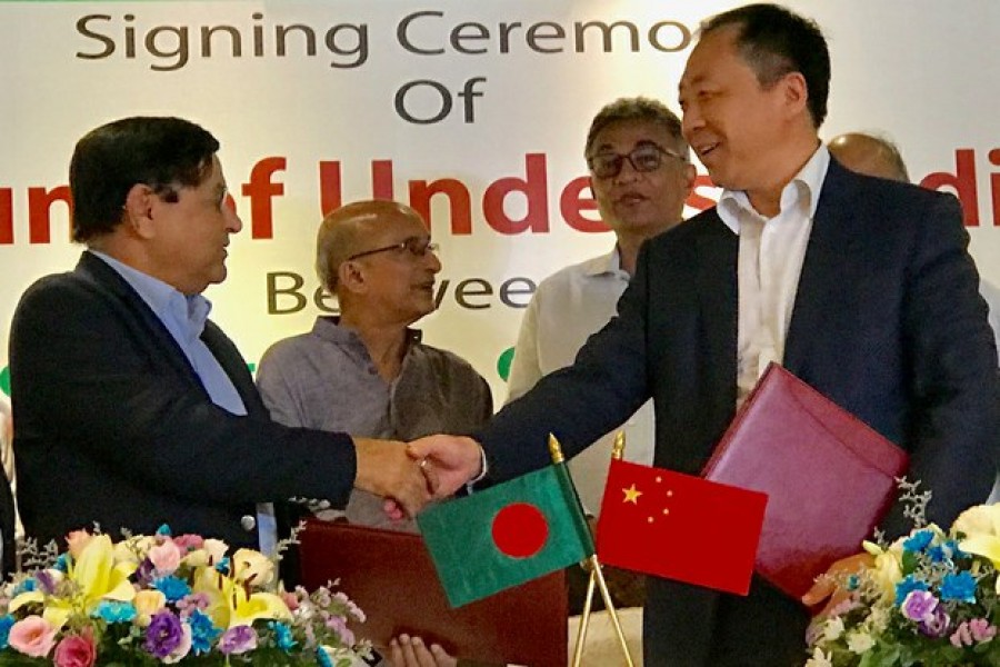 A.M. Khurshed Alam, chief executive officer of the NWPGC, shakes hands with Ruan Guang, chairman of the CMC, after they signed a MoU on implementing the renewable energy projects. (Photo- collected)