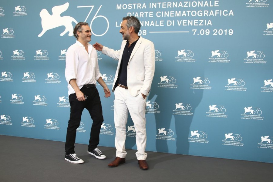 Actor Joaquin Phoenix, left, greets director Todd Phillips at the photo call for the film 'Joker' at the 76th edition of the Venice Film Festival in Venice, Italy, Saturday, Aug. 31, 2019. (Photo by Joel C Ryan/Invision/AP)