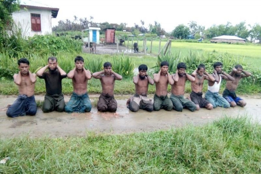 Ten Rohingya Muslim men with their hands bound kneel in Inn Din village on September 1, 2017. They are said to have been executed by Myanmar soldiers and dumped in a shallow grave. Handout via Reuters