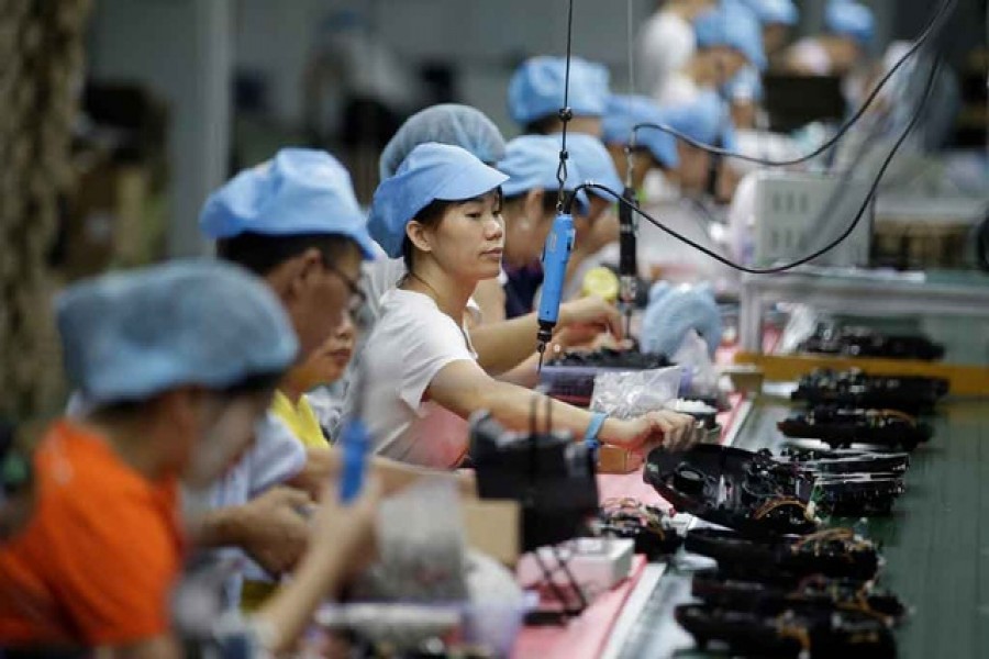 Employees work on the production line of a robot vacuum cleaner factory of Matsutek in Shenzhen, China, August 9, 2019. Reuters/Files
