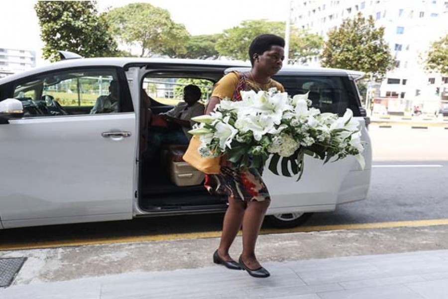A visitor arrives with a wreath at the Singapore Casket funeral parlor building where the body of Robert Mugabe was being held on September 07, 2019, in Singapore.         — Photo: AP   