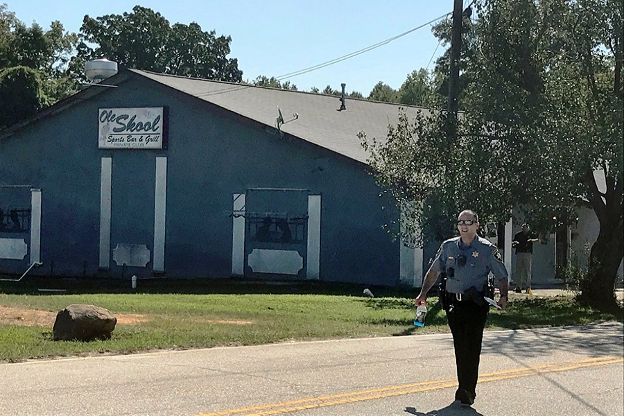 A Lancaster County Sheriff's deputy walks around the Old Skool Sports Bar and Grill, the scene of a shooting early in the morning, north of Lancaster, SC on September 21, 2019 — AP photo