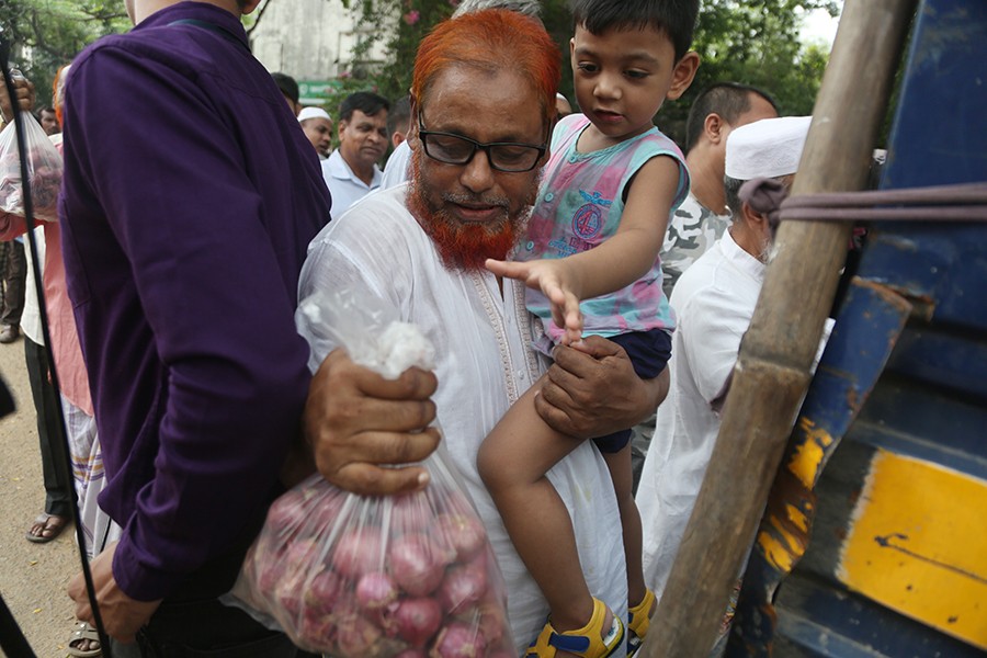 A man buying onion from a TCB sale point near the Jatiya Press Club in the city on Sunday. The Trading Corporation of Bangladesh (TCB) started selling onion under open market sale in the wake of sudden price hike of the essential kitchen item — FE photo