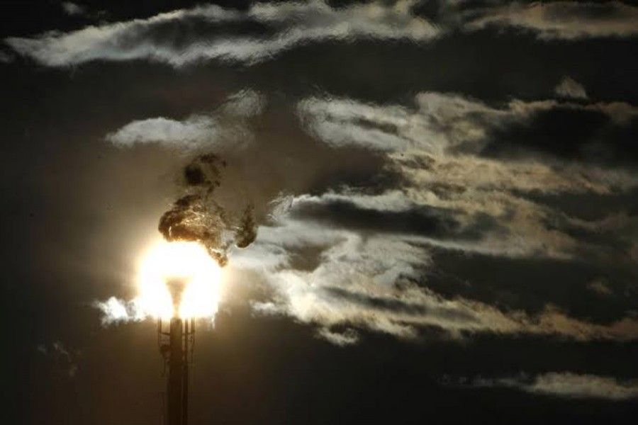 A flare stack emitting fire is silhouetted against the sun at an oil refinery in Melbourne June 24, 2009. Reuters/File Photo