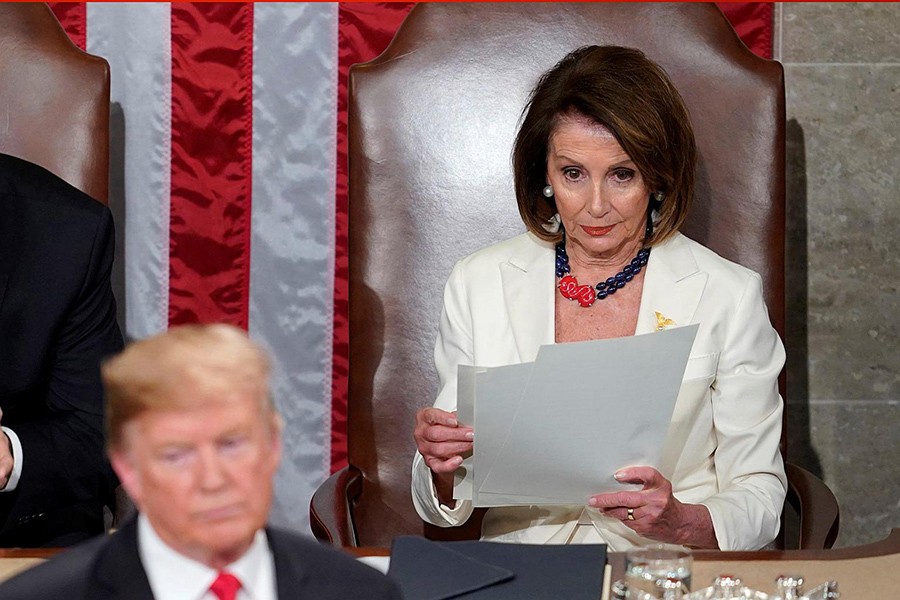 Top Democrat Nancy Pelosi (right) remains in her seat and looks through a copy of the speech as US President Donald Trump arrives to deliver his second State of the Union address on February 5, 2019 — Reuters/Files