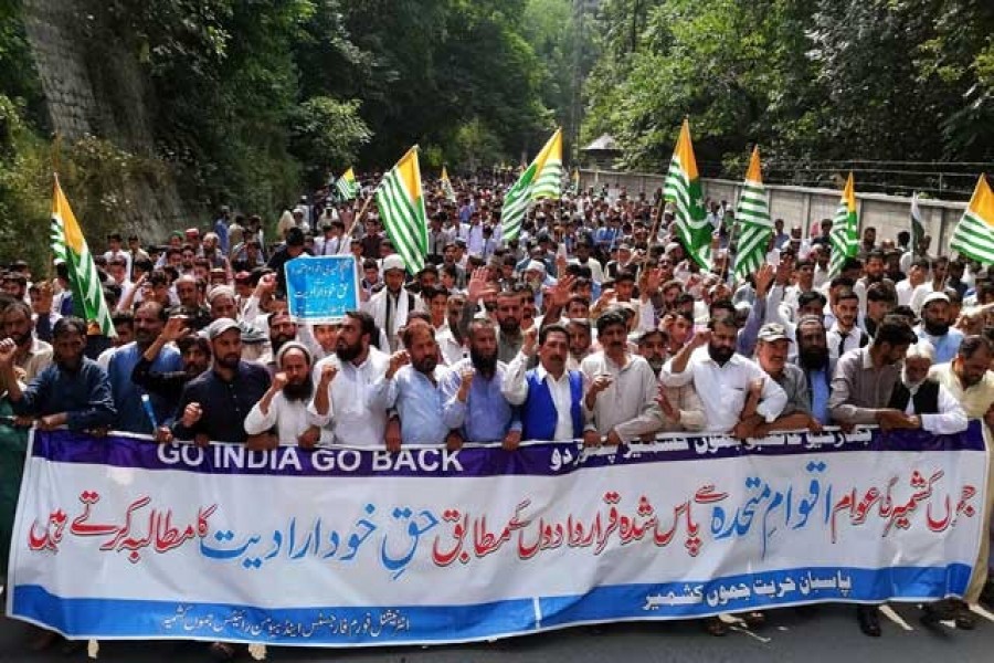 People carry flags and signs as they march towards UN office during a rally to express solidarity with the people of Kashmir, in Muzaffarabad, Pakistan, Sep 26, 2019. REUTERS