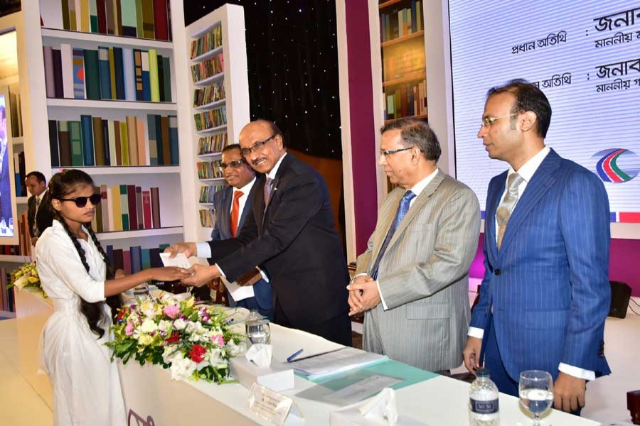 Governor of Bangladesh Bank Fazle Kabir handing over scholarship to an awardee in a programme organised by Dutch-Bangla Bank Limited in the city on Saturday