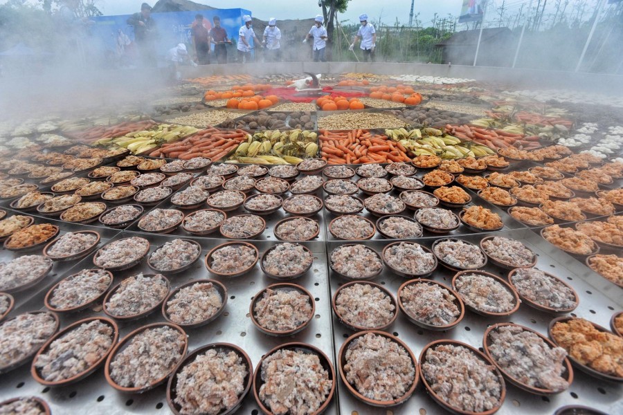 FILE PHOTO: Steamed dishes are seen on a giant food steamer for an event at a tourist attraction in Xiantao, Hubei province, China April 26, 2019. REUTERS/Stringer