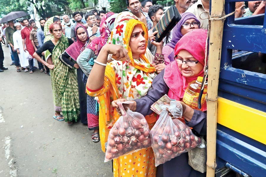 A woman leaving the queue after buying onion from a truck used for running open market sale (OMS) of the item near Jatiya Press Club in the city on Thursday — FE photo by Shafiqul Alam