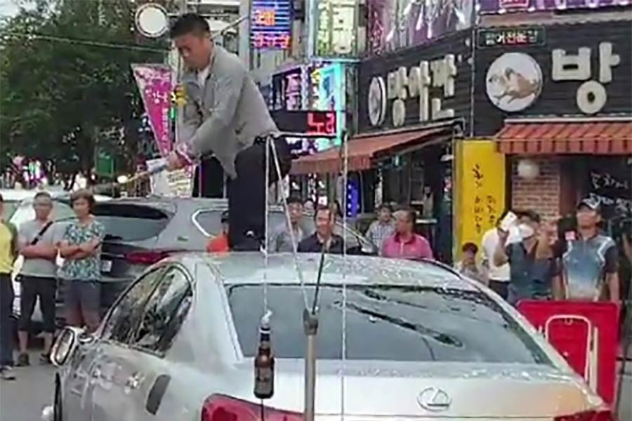 A man smashing up his Japanese-made car in protest at the trade dispute