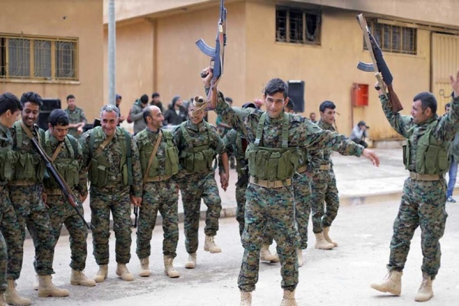 Fighters from a new border security force under the command of Syrian Democratic Forces (SDF) dance during a graduation ceremony in Hasaka. Reuters