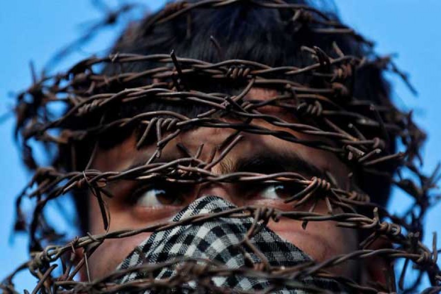 A masked Kashmiri man with his head covered with barbed wire attends a protest after Friday prayers during restrictions following the scrapping of the special constitutional status for Kashmir by the Indian government, in Srinagar, Oct 11, 2019. REUTERS