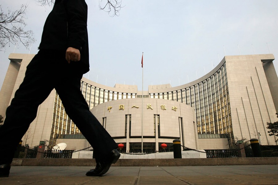 A man walks past the headquarters of the People's Bank of China (PBOC), the central bank, in Beijing — Reuters/Files