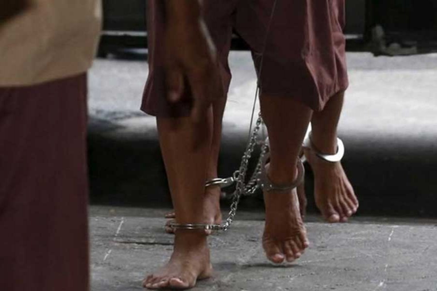 The shackled legs of suspected human traffickers are seen as they arrive for their trial at the criminal court in Bangkok, Thailand, Mar 15, 2016. REUTERS