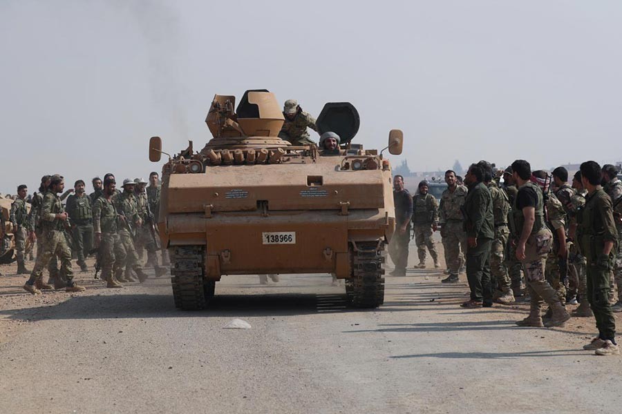 Turkey-backed Syrian rebel fighters gathering as a military vehicle advances near the border town of Tal Abyad in Syria on October 24, 2019. -Reuters Photo