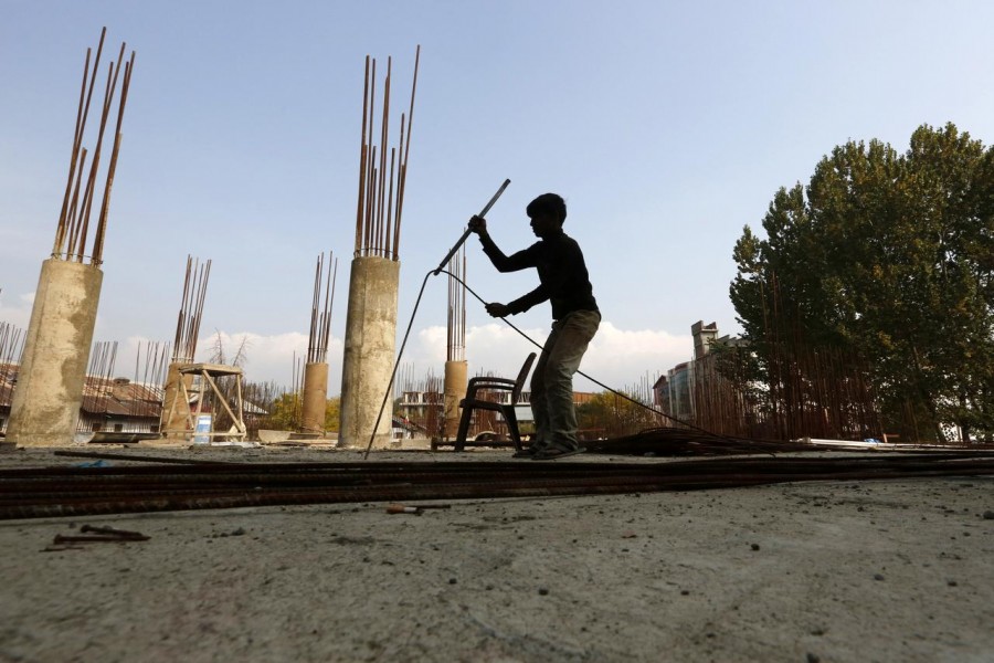 A migrant worker straightens an iron rod at the construction site of a parking lot in Srinagar October 30, 2019. Picture taken October 30, 2019. REUTERS/Danish Ismail