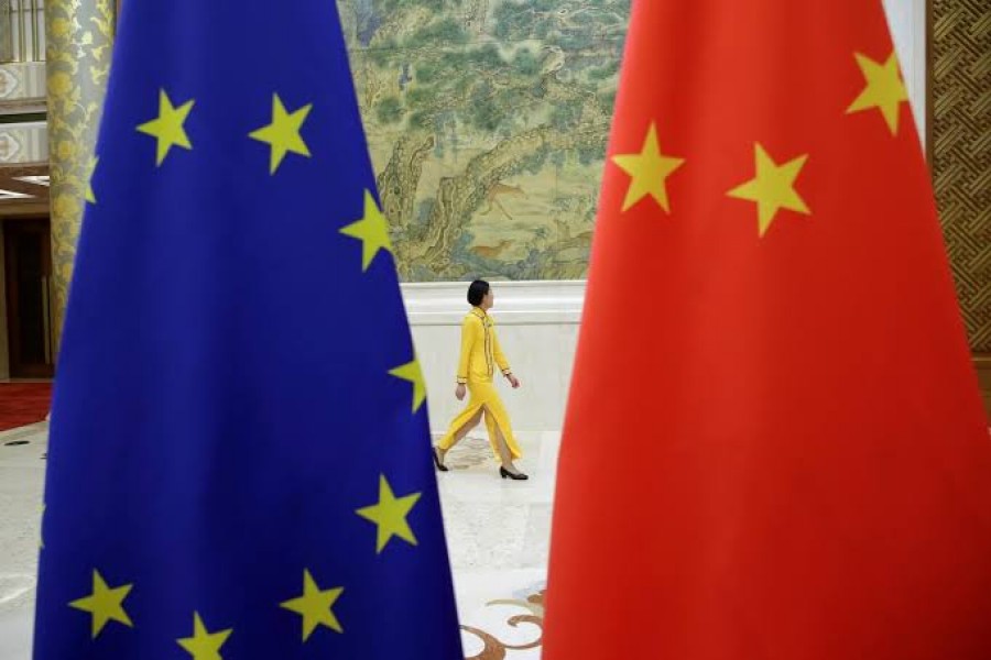 FILE PHOTO: An attendant walks past EU and China flags in Beijing, China June 25, 2018. REUTERS/Jason Lee