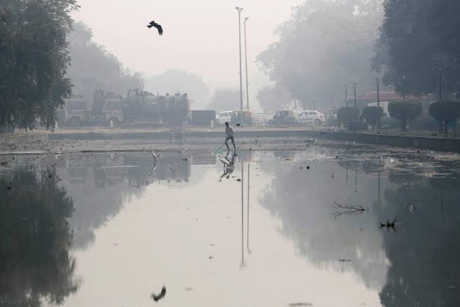A man cleans a pond on a smoggy morning in New Delhi, November 11, 2019. REUTERS/Adnan Abidi