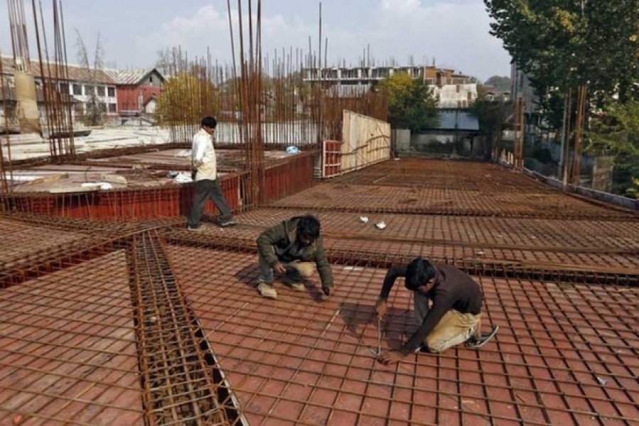 Migrant workers fasten iron rods together at the construction site of a parking lot in Srinagar Oct 30, 2019. REUTERS