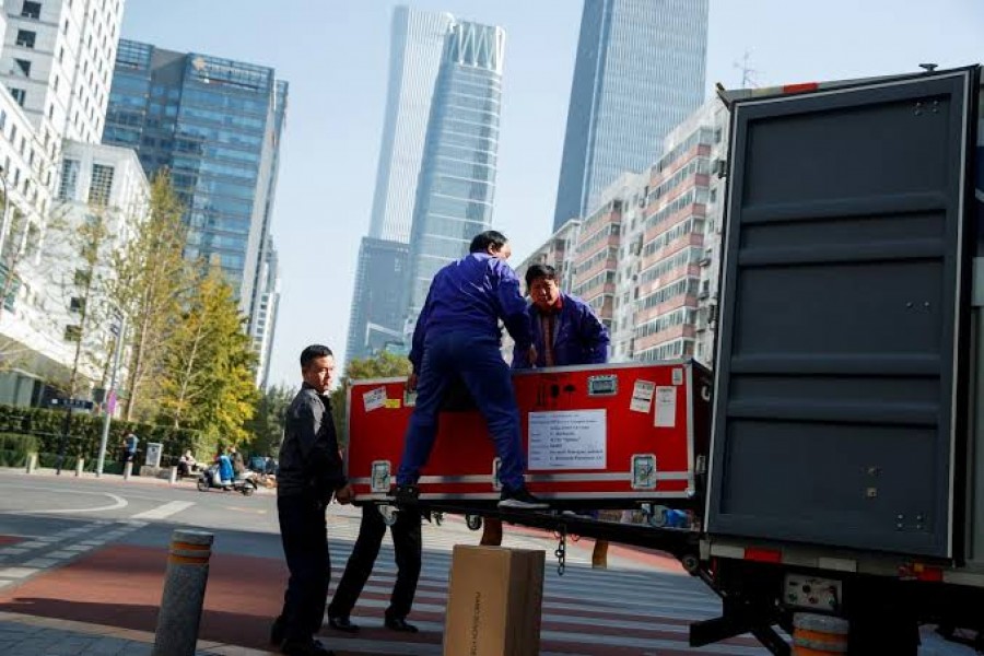 Men unload cargo from the truck of a logistics firm in Central Business District in Beijing, China October 29, 2019. Picture taken October 29, 2019. REUTERS/Thomas Peter