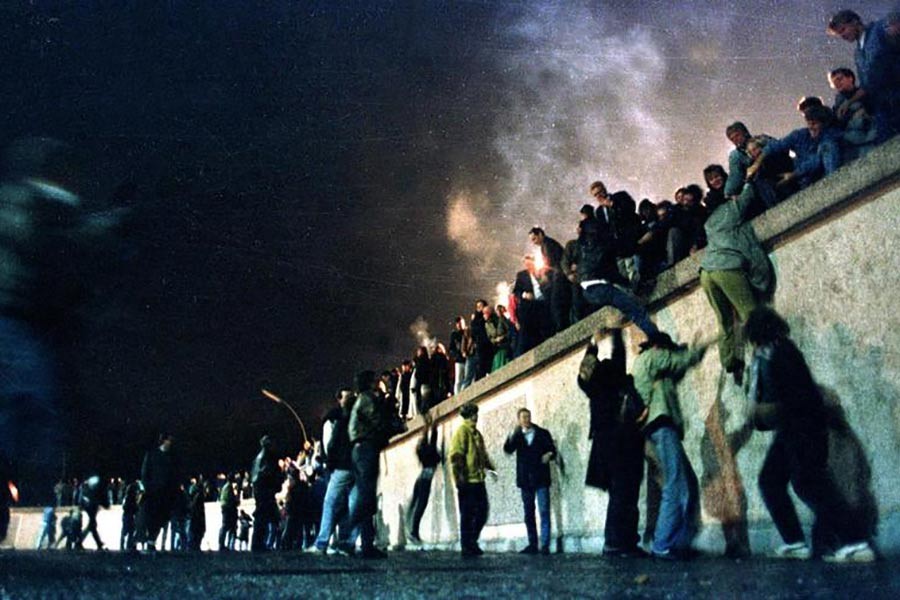 East German citizens climbing the Berlin wall at the Brandeburg gate after the opening of the East German border was announced, November 10, 1989. -Reuters file photo