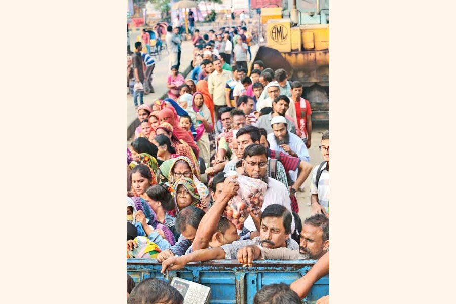People waiting in long queues to buy onion from a TCB sale point in Khamarbari area of the city on Tuesday— FE photo