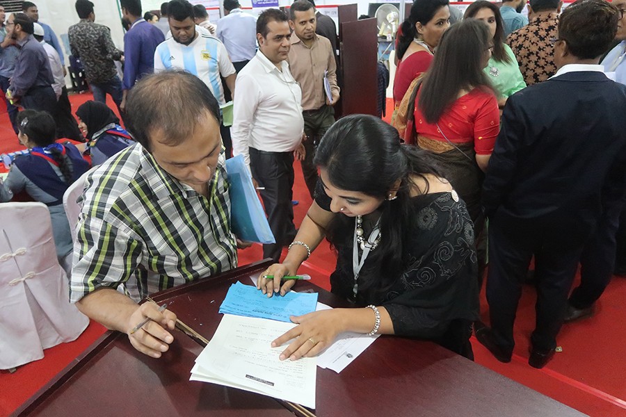 A tax official helping a man file his tax return at the Tax Fair at the Officers Club in the city on its concluding day on Wednesday — FE photo